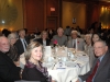 dinner guests seated at table smiling for photo