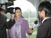 women holding mircrophone, camera man interviewing student