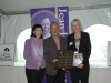 three people holding plaque