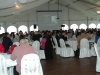 white reception tent with guests seated at round tables