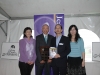 four people holding plaque