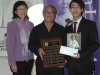 Jthree people holding plaque