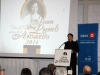 man speaking behind podium with Jean Lumb Foundation logo projected in background