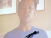 young man speaking speaking on large projector screen