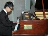 musician playing at grand piano.