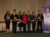 student award winner holding their plaques with a photo of Jean Lumb