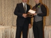 man handing plaque award to student winner