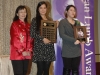 two award winners holding their plaques beside Jean Lumb banner