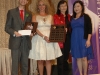 four people together for photo. Students holding their plaques