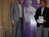 Two people standing beside Jean Lumb banner.