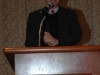 Man speaking behind podium.