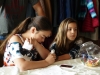 Two young girls drawing henna tattoos.