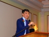 Man smiling and speaking into microphone.
