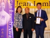 Three people posing for photo under Jean Lumb sign.