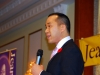 Man addressing audience with microphone.