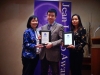 Two students holding their awards with Arlene Chan
