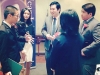 five people having a conversation while standing in a circle.