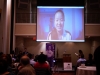 Large projector screen showing student's acceptance speech.
