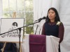 student speaking into micrphone behind podium.