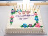 Bithday cake with flowers and gold candles to honour Jean Lumb.